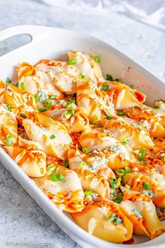 Vertical photo of white casserole dish with Buffalo Chicken Stuffed Shells Before Serving