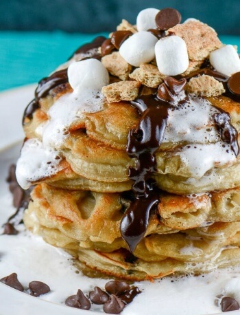stack of pancakes with melted chocolate and melted marshmallows dripping down the sides.