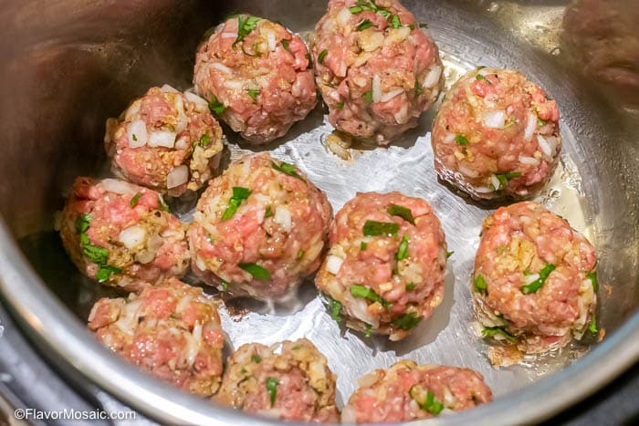An overhead picture of the meatballs cooking on saute setting in an Instant Pot Pressure Cooker