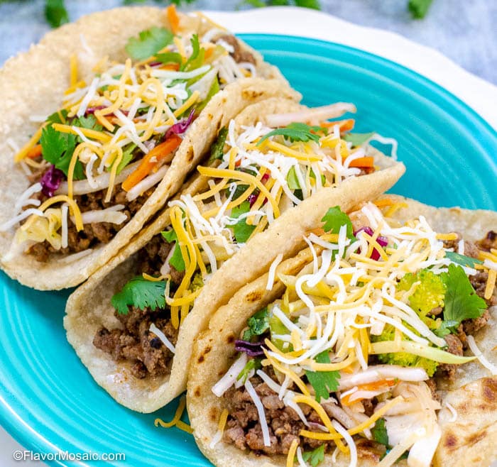 Photo of 3 ground beef tacos on blue plate