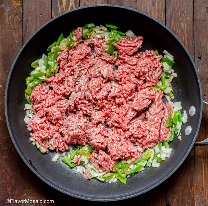 raw ground beef in skillet to cook ground beef tacos.