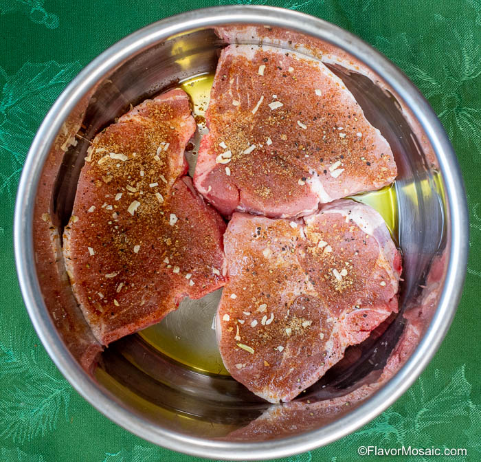 Square overhead photo of seasoned pork chops in Instant Pot.