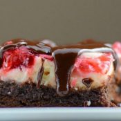 Side view of Cherry Cheesecake Brownies drizzled in chocolate ganache