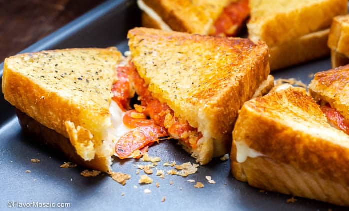 Baked Pizza Grilled Cheese Sandwiches laying on a sheet pan.