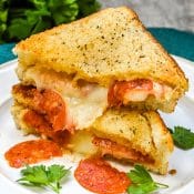 Baked Pizza Grilled Cheese Sandwiches stacked on a white plate