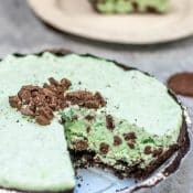 Grasshopper Pie, like chocolate mint pie, with one slice removed and placed on a white plate in background.