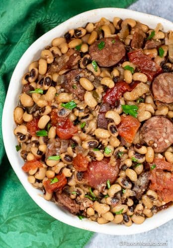 Overhead view of white bowl with Instant Pot Black Eyed Peas with tomatoes, sausage, and bacon.