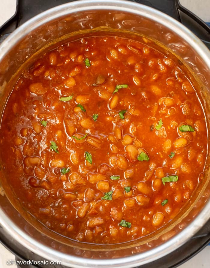 Overhead view of baked beans garnished with chopped cilantro inside the Instant Pot.