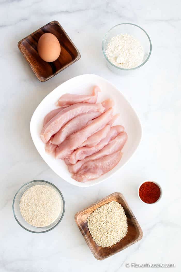 Overhead view of ingredients for Sesame chicken strips - egg, raw chicken strips, etc.