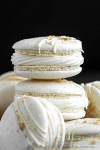 Side view of a stack of Apple Pie Macarons against a black background.