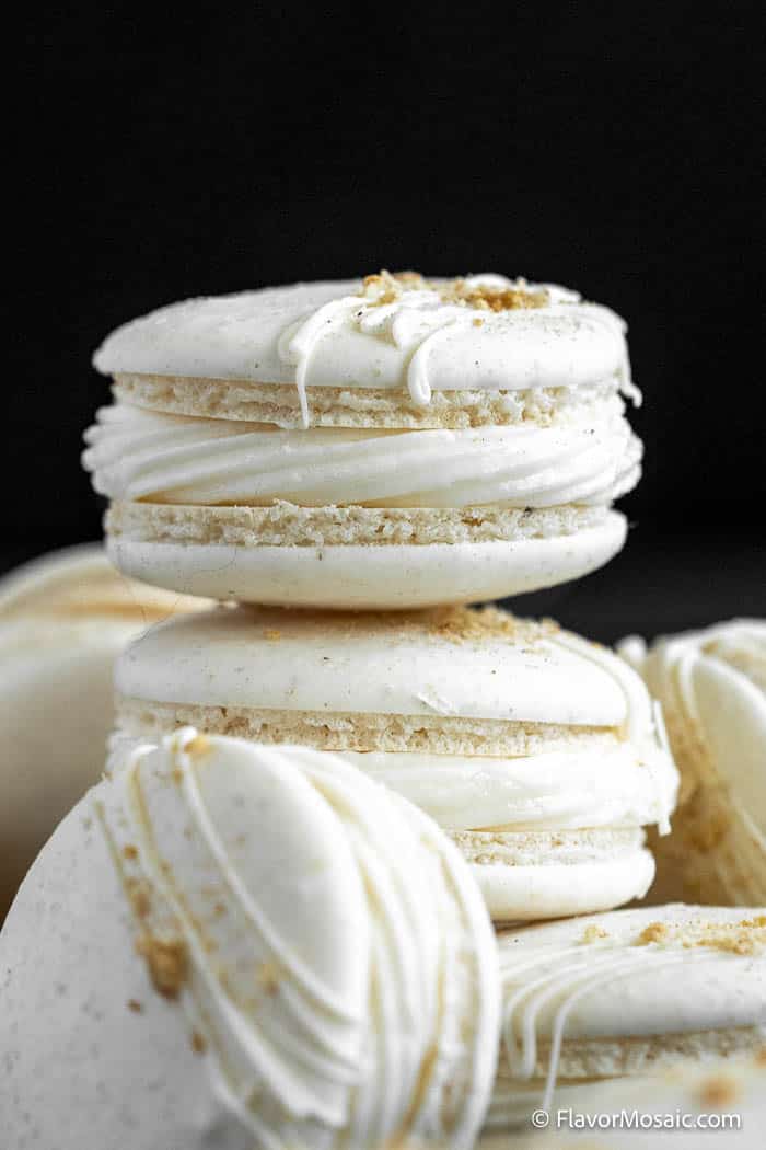 Side view of a stack of Apple Pie Macarons against a black background.