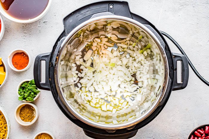 Overhead view of the inside of an Instant Pot while sautéing onions in oil.