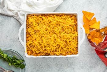 Showing the shredded cheese covering the top of all of the casserole.