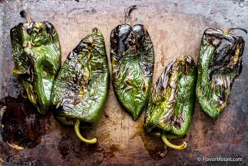 Oven roasted or broiled poblano peppers for Chile relents casserole before being peeled.