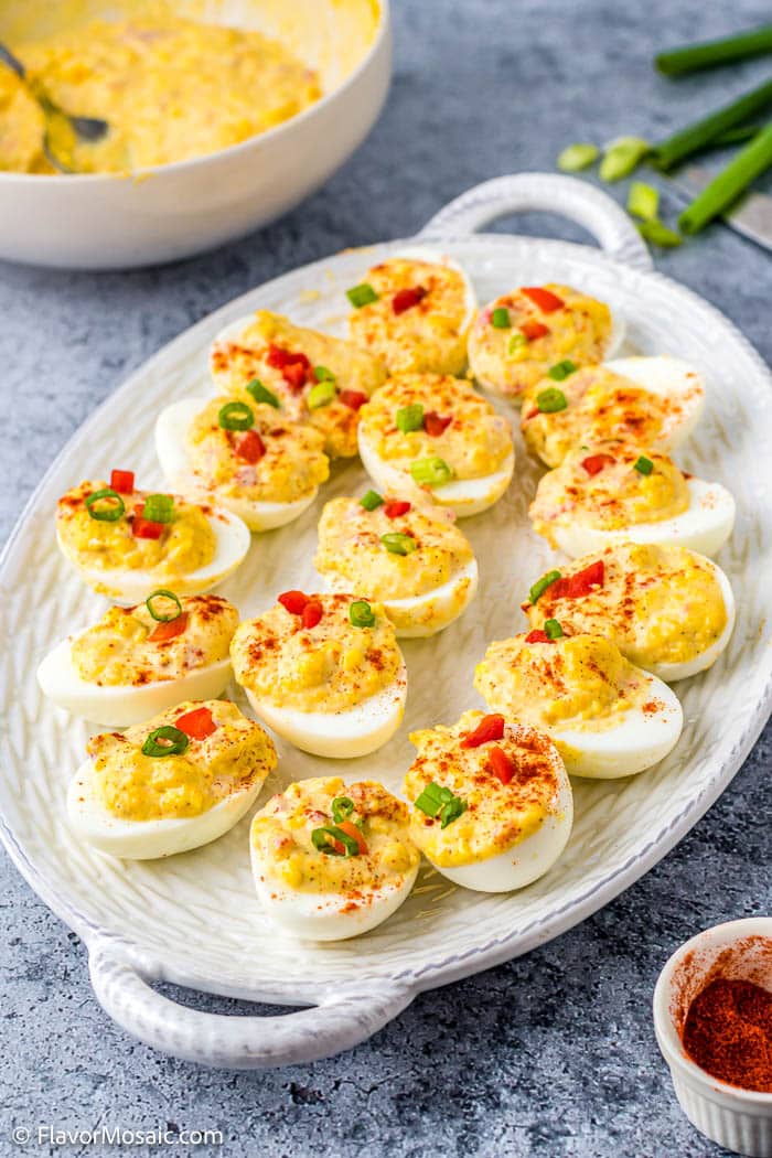 Large white platter on gray countertop with about 15 Pimento Cheese Deviled Eggs