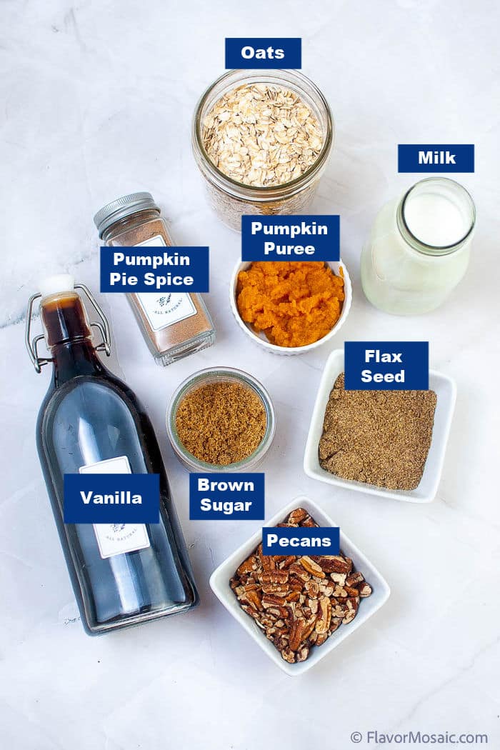 Overhead photo of individual ingredients for pumpkin pie overnight oats, each in individual containers, on a white marble background.