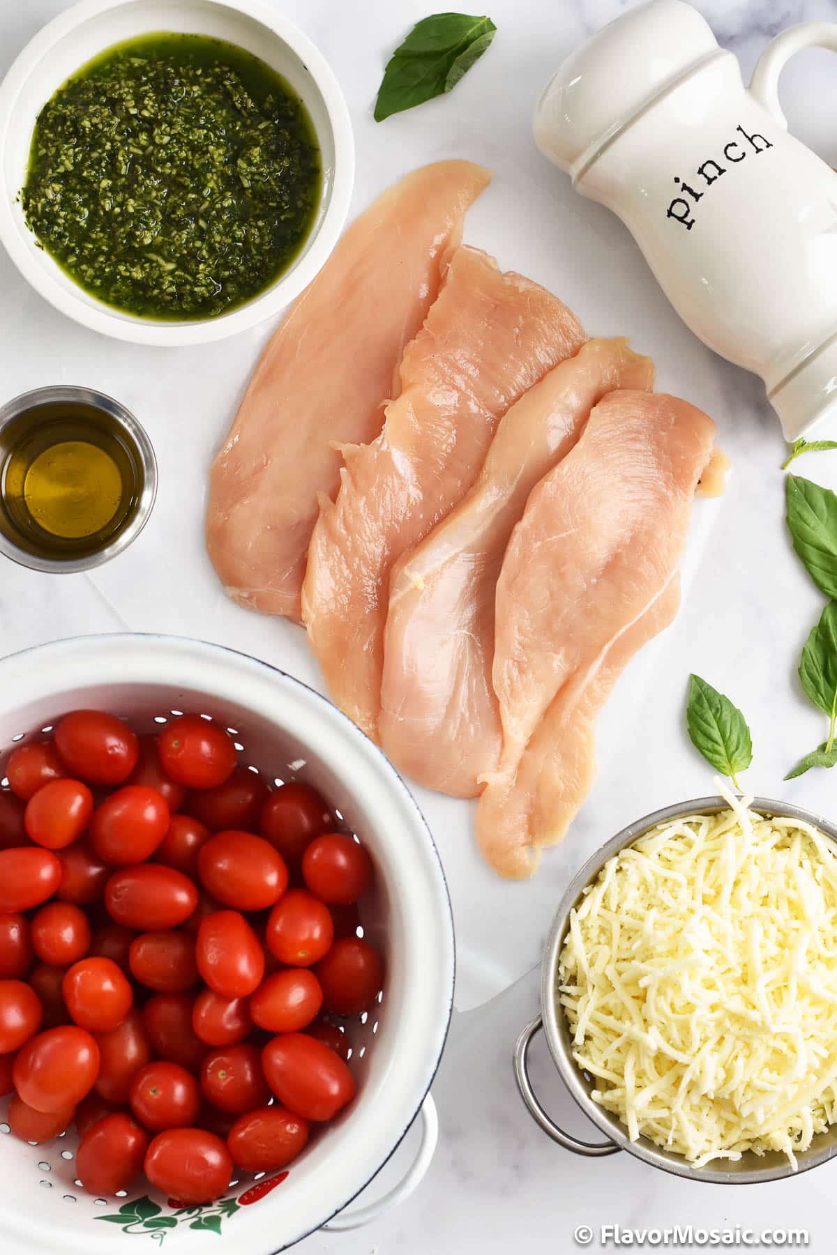 Overhead view of the ingredients for Baked Pesto Chicken on a white background.
