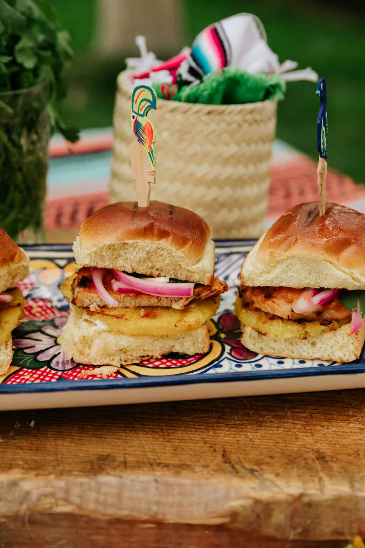 Mexican Pork Chop Sliders on a colorful serving tray with a basket in the background.